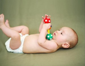 child clasps hand, can hold objects